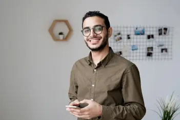 Mann hält ein Smartphone in der Hand und lacht