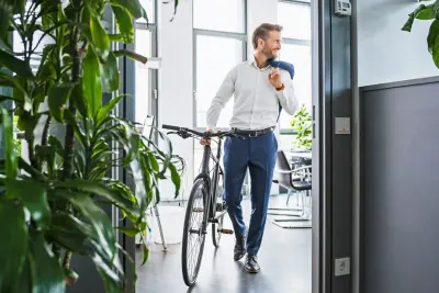 Mann mit Fahrrad verlässt das Büro