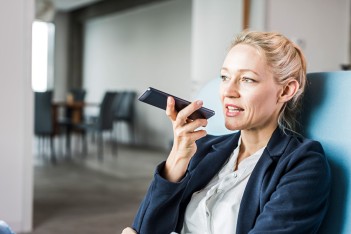 Eine weibliche Führungskraft nimmt eine Nachricht mit dem Handy auf