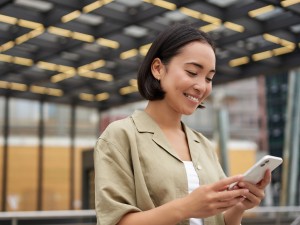 Asiatische Frau schaut auf ihr Smartphone