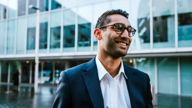 Mann mit Anzug und Brille lächelt