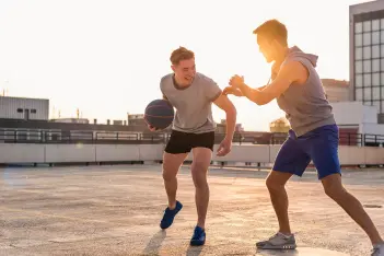Zwei junge Männer spielen Basketball