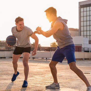 Zwei junge Männer spielen Basketball