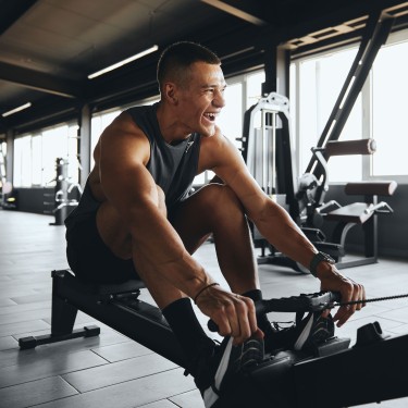 Junger Mann macht Funkton-Trainung auf einem Rudergerät