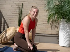 Lachende Yoga-Trainerin auf einer Yoga-Matte