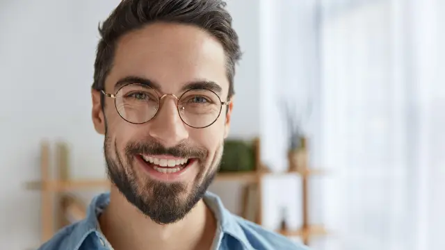 Ein Mann mit Brille lächelt