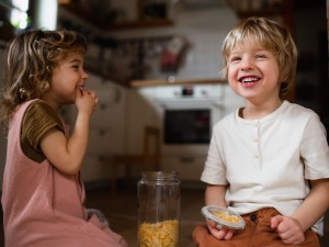 Zwei Kinder naschen Cornflakes