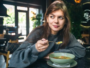 Frau steht vor Gemüseregal im Supermarkt