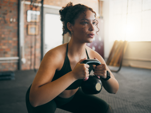 Junge Frau im Fitnessstudio mit Kettlebell