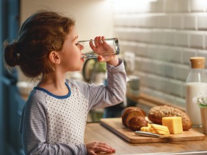 Kind trinkt Wasser aus Glas