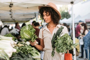 Junge Frau löffelt eine Gemüsesuppe