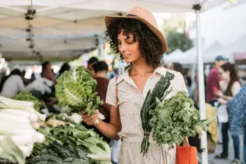 Junge Frau löffelt eine Gemüsesuppe