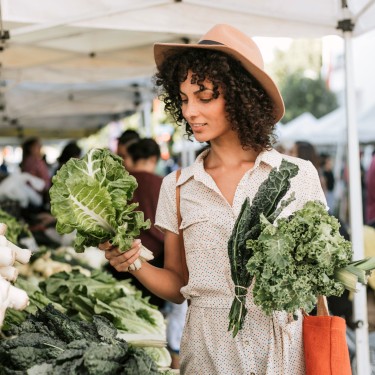 Junge Frau löffelt eine Gemüsesuppe