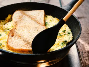 Das Rührei mit dem Toast in der Pfanne