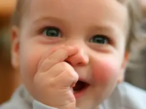 Ein lächelndes Baby lutscht am Daumen