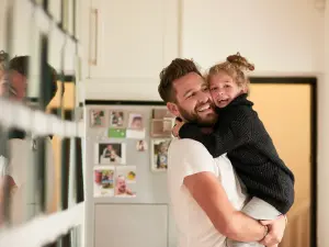 Familienleben: Mann trägt Mädchen auf dem Arm
