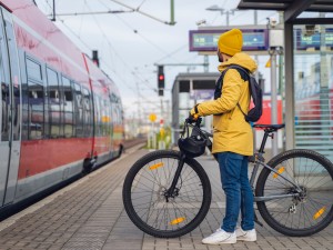 Mann mit Fahrrad am Bahnhof