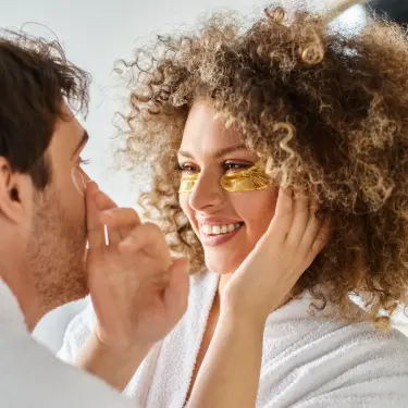 Ein Paar kümmert sich gegenseitig um die Hautpflege im Gesicht.