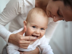 Zahnpflege: Frau reinigt die Zähne eines Babys