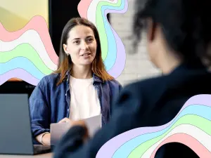 Eine Frau im Büro im Gespräch mit einer weiteren Person im Vordergrund