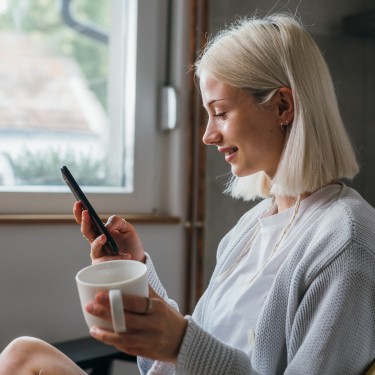 Junge Frau schaut auf ihr Handy