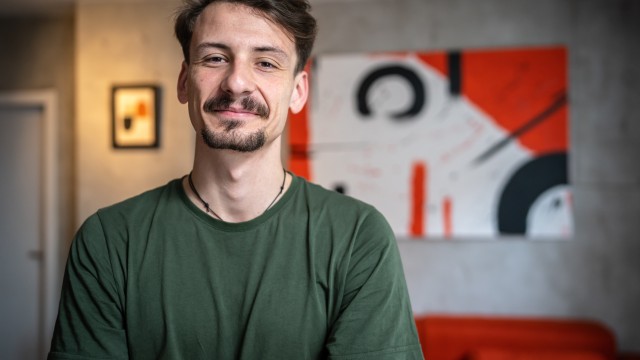 Das Porträt eines junges Mannes vor einem Bild. 