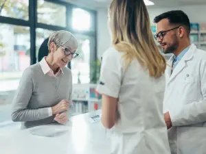 Eine ältere Frau wird in einer Apotheke beraten