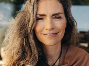 Wechseljahre: Eine Frau in Nahaufnahme lächelt in die Kamera