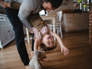 Ein Vater schwingt seine Tochter im Spiel durch die Luft