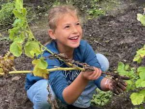 Glückliches Mädchen auf einem Acker bei der Ernte