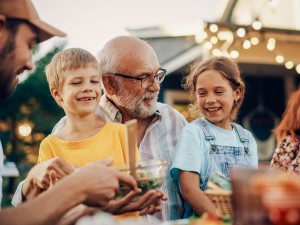 Älterer Mann und 2 Kinder lachen glücklich zusammen