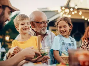 Älterer Mann und 2 Kinder lachen glücklich zusammen
